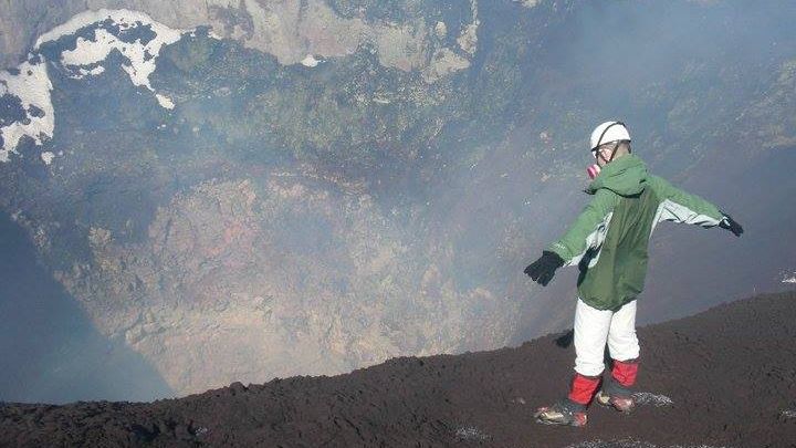 Telfer standing at the rim of a volcano and looking into the crater